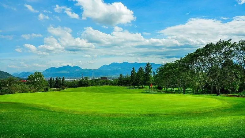 Green lapangan Giri Gahana Golf Bandung dengan panorama perbukitan dan langit cerah.